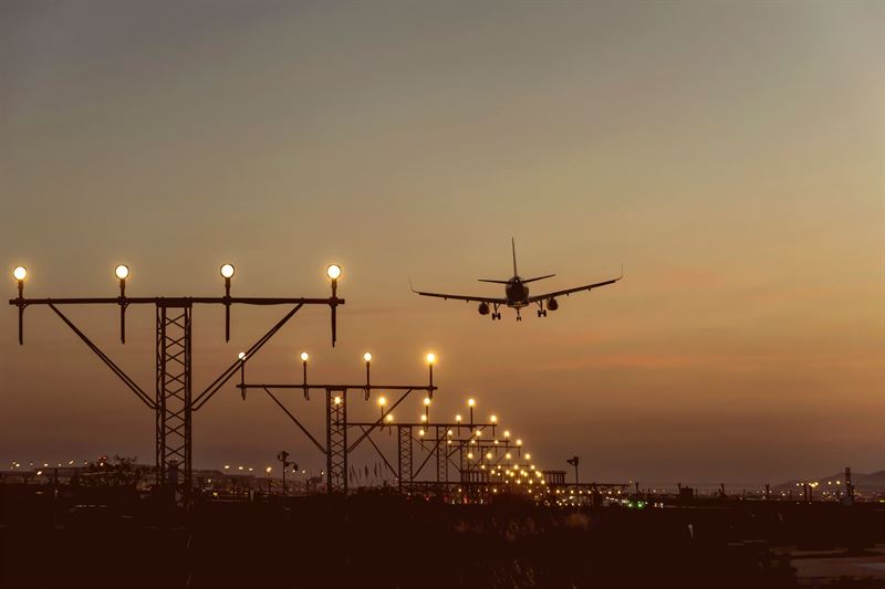 Aircraft landing at airport with guiding lights